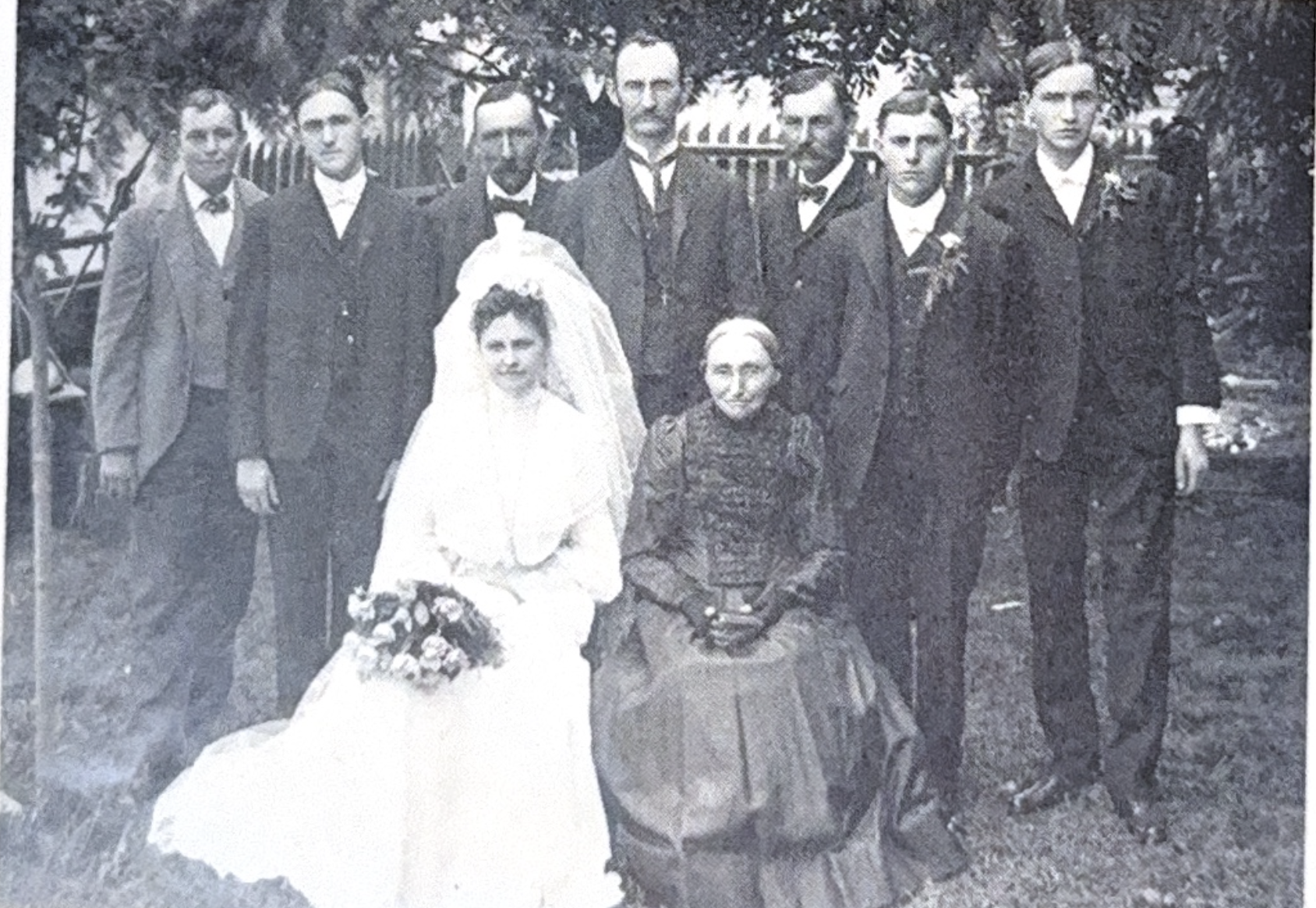 Large family wedding photograph with bride in white dress and multiple family members